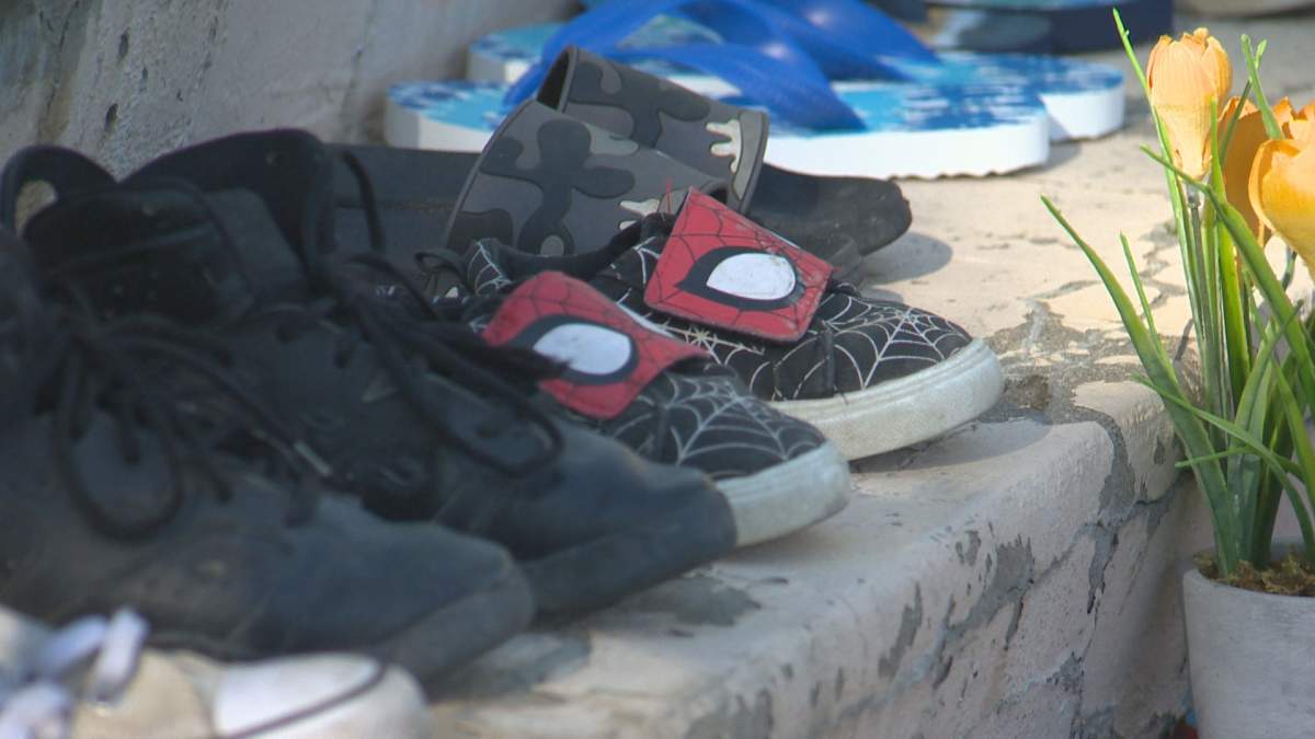 Shoes and flowers placed on the steps of St. Patrick's Church in Lethbridge, Alta., at a vigil honouring the 215 children found in unmarked burial sites at Kamloops Indian Residential School, Monday, May 31, 2021.