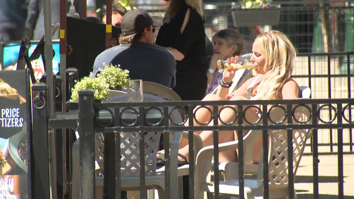 A woman enjoys a beverage on a Calgary patio on Tuesday, June 1, 2021.