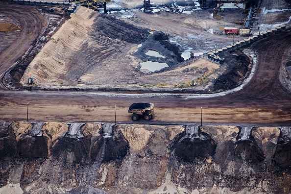 A heavy hauler truck drives through the Syncrude Canada Ltd. Aurora North mine in this aerial photograph taken above the Athabasca oil sands near Fort McMurray, Alberta, Canada, on Monday, Sept. 10, 2018. 