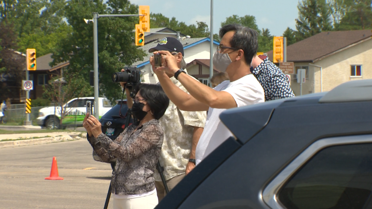 Parents taking photos of the drive-thru convocation ceremony held at Maples Collegiate on Friday.