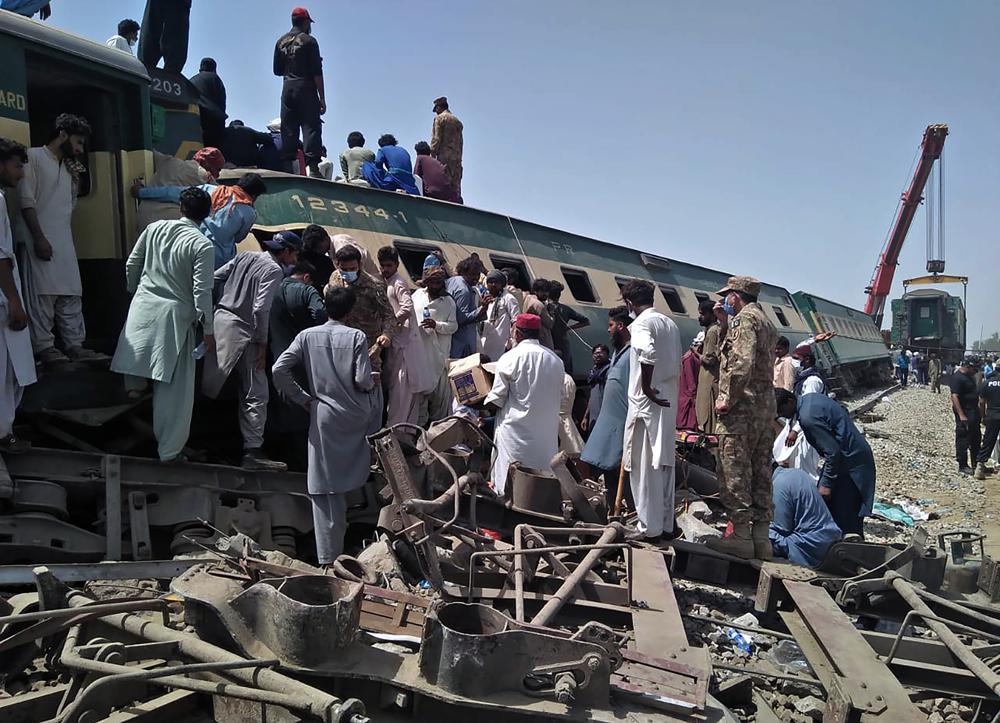 Soldiers and volunteers work at the site of a train collision in Ghotki district in southern Pakistan, Monday, June 7, 2021.