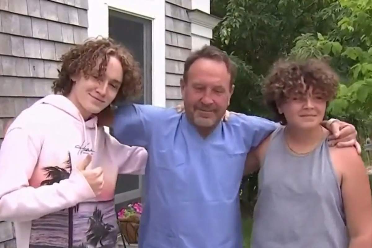 Michael Packard hugs his family in front of the media after returning home from the hospital.