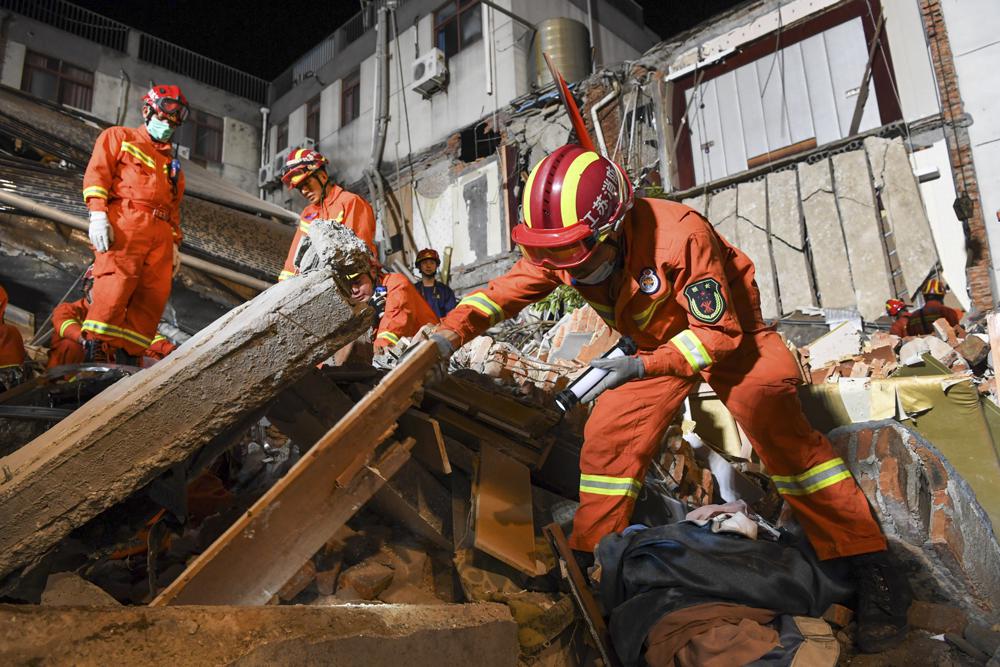 In this photo released by Xinhua News Agency, rescuers search for survivors at a collapsed hotel in Suzhou in eastern China's Jiangsu Province, Monday, July 12, 2021. The hotel building collapsed Monday afternoon. 