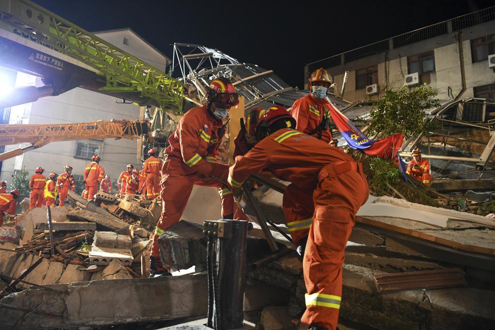 In this photo released by Xinhua News Agency, rescuers prepare equipment as they search for survivors at a collapsed hotel in Suzhou in eastern China's Jiangsu Province on Monday, July 12, 2021. The hotel building collapsed Monday afternoon. (Li Bo/Xinhua via AP).