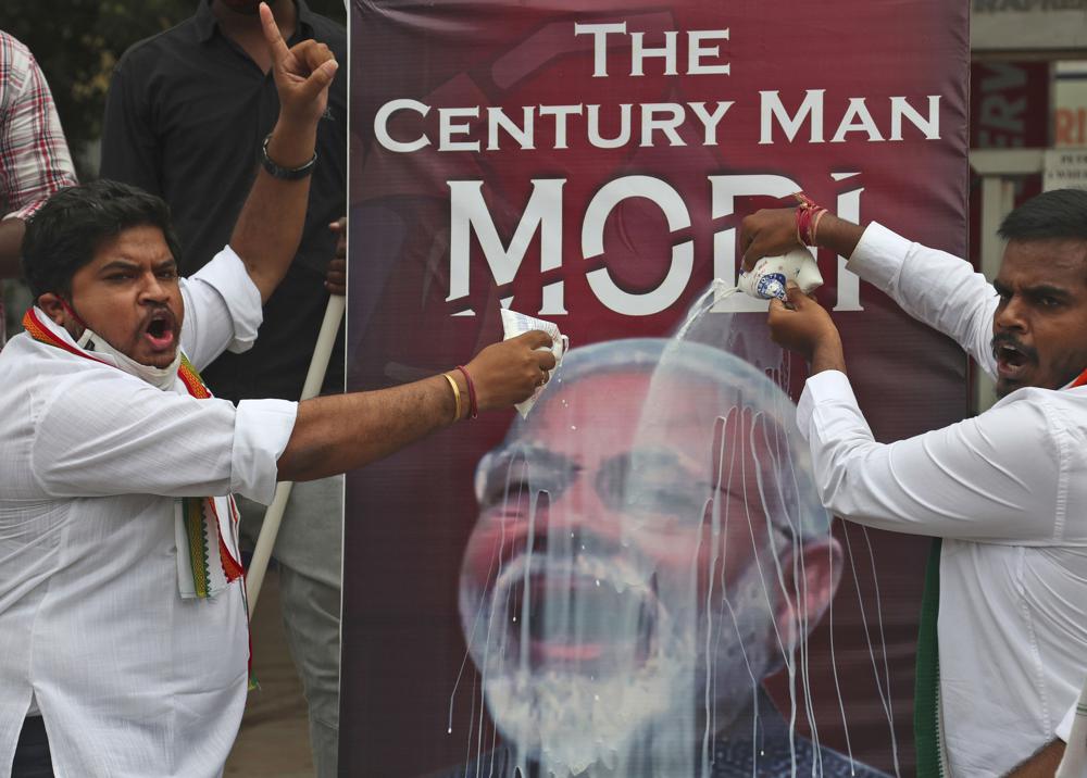 n this Friday, June 11, 2021 file photo, activists of India’s opposition Congress party pour milk over a poster of Indian Prime Minister Narendra Modi, to mockingly celebrate fuel price reaching the century mark, during a protest against the hike of petrol and diesel price in Hyderabad, India.