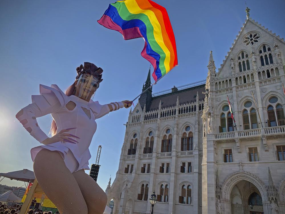 In this file photo dated June. 14, 2021, a drag queen waves a rainbow flag during an LGBT rights demonstration in front of the Hungarian Parliament building in Budapest, Hungary.