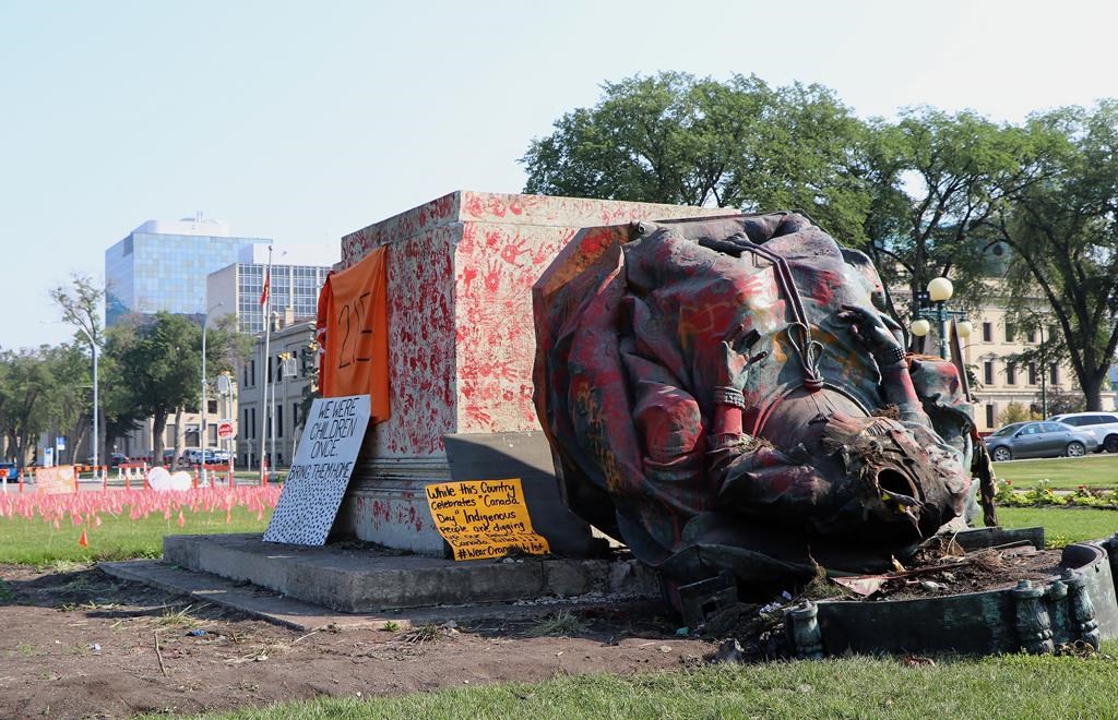 A headless statue of Queen Victoria is seen overturned and vandalized on the Manitoba legislature grounds in Winnipeg on Friday, July 2, 2021.