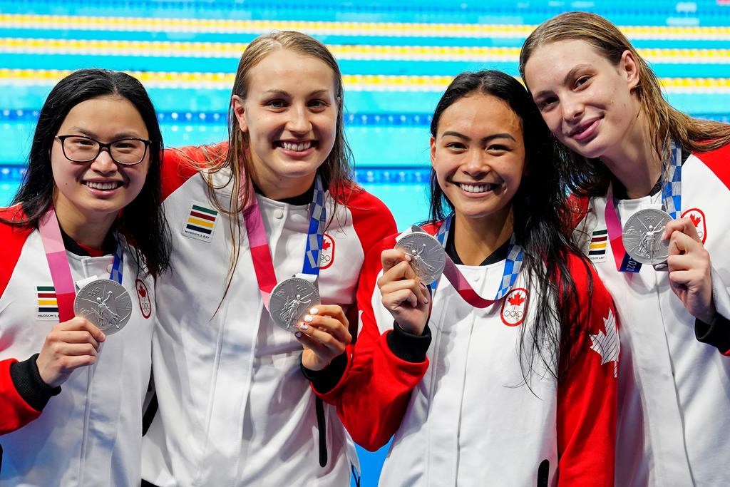 Canada’s Margaret Mac Neil, left to right, Rebecca Smith, Kayla Sanchez and Penny Oleksiak celebrate a silver medal in the women’s 4 x 100m freestyle relay during the Tokyo Olympics in Tokyo, Japan on Sunday, July 25, 2021.