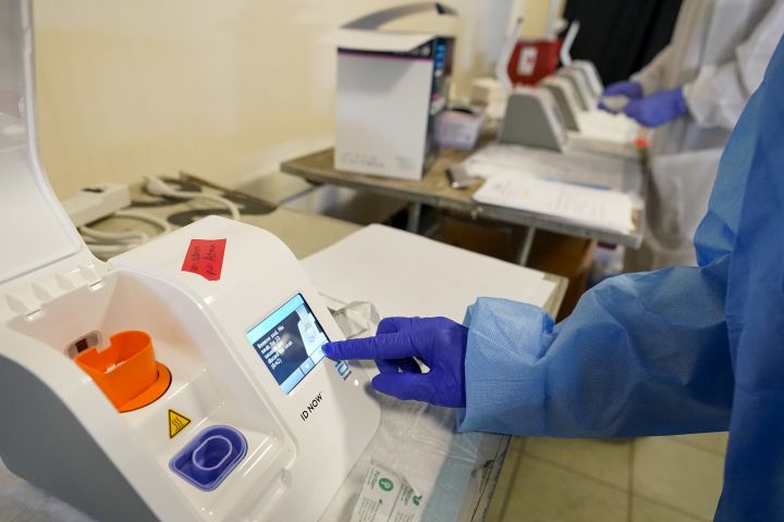 File photo of a lab technician using a COVID-19 rapid tester. 