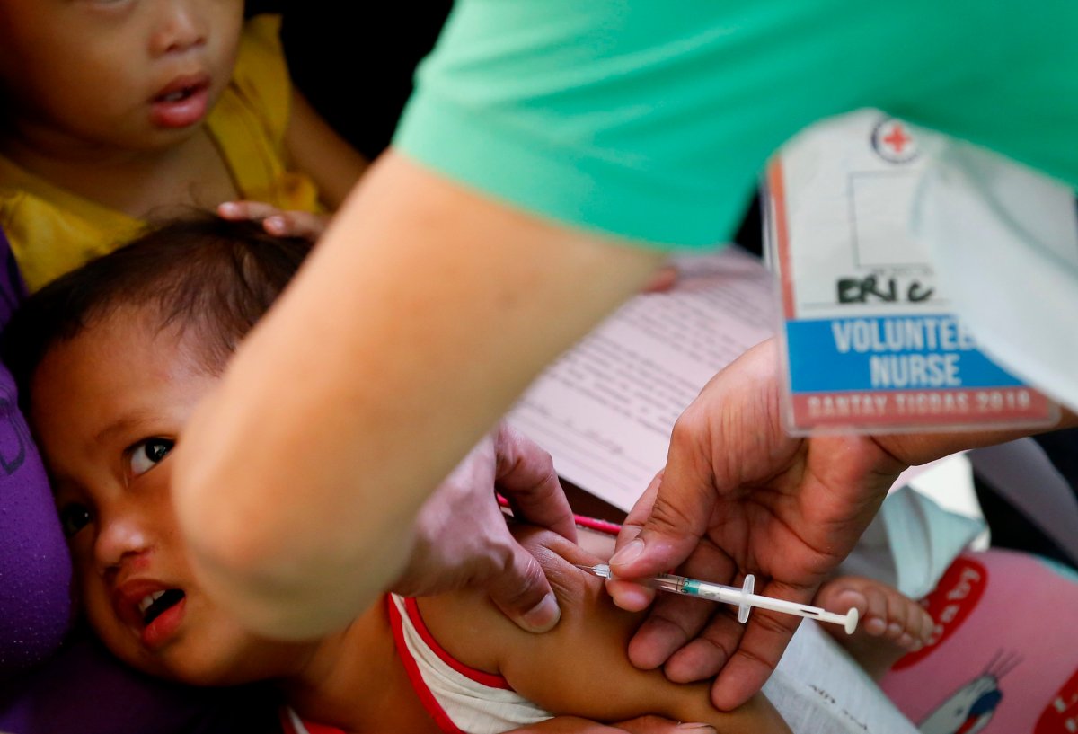 FILE - In this Feb. 16, 2019, file photo, Philippine National Red Cross and Health Department volunteers conduct house-to-house measles vaccination to children at an informal settlers community in Manila, Philippines. (AP Photo/Bullit Marquez, File).