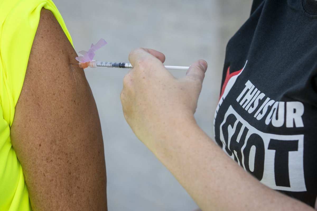 A person receives COVID-19 vaccine during a clinic at Richardson stadium in Kingston, Ontario on Friday July 23, 2021. THE CANADIAN PRESS IMAGES/Lars Hagberg.