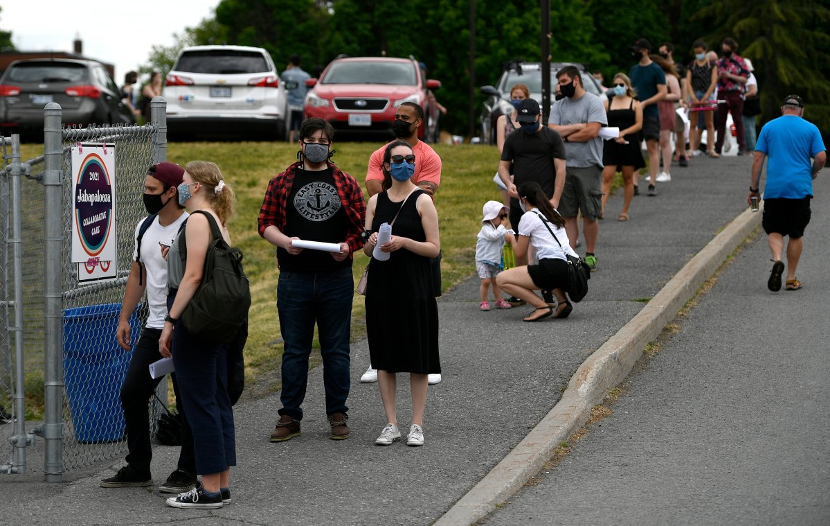 People line up for their appointments at an outdoor, pop-up COVID-19 vaccination clinic nicknamed "Jabapalooza" on the soccer field at Immaculata High School in Ottawa, on Saturday, June 5, 2021. 
