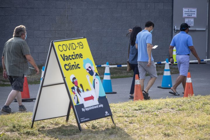 People wear masks outside the COVID-19 vaccine clinic at Quinte Sports and Wellness Centre in Belleville, Ontario on Monday June 28, 2021.