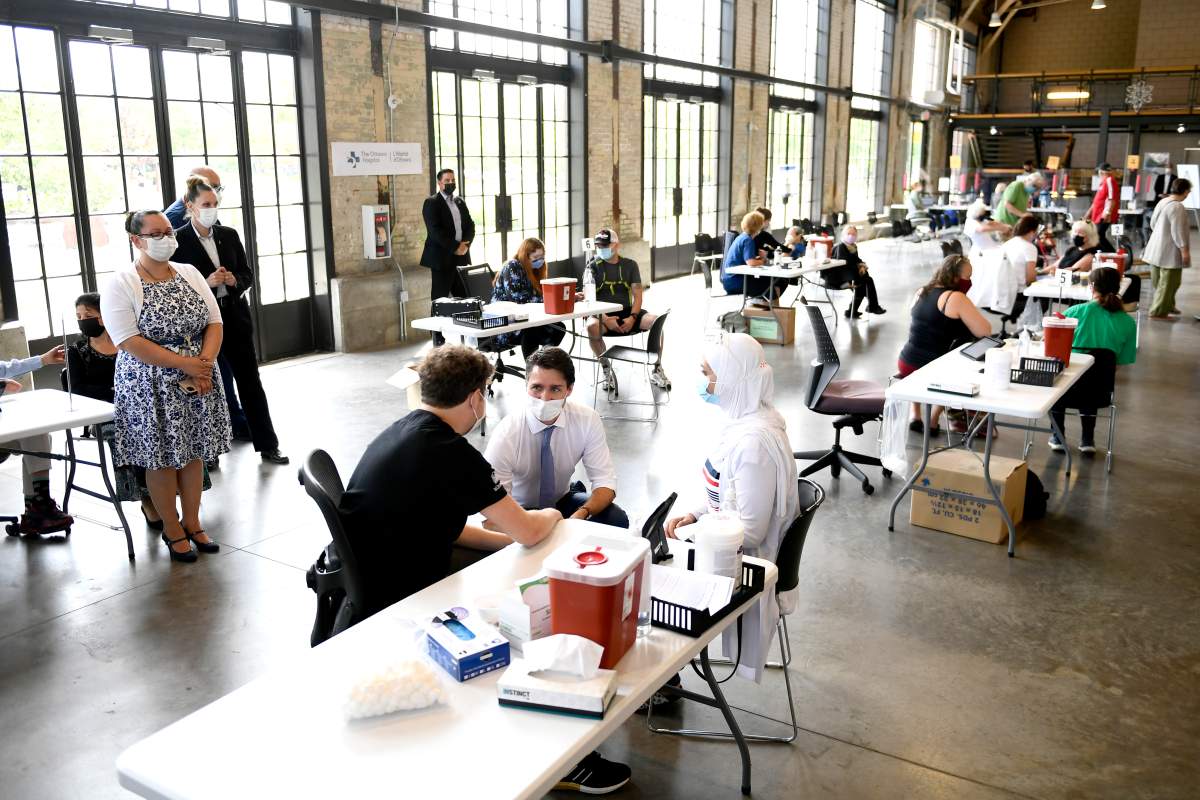 Prime Minister Justin Trudeau speaks with health-care workers and people receiving COVID-19 vaccines at a clinic in Ottawa, on Friday, July 2, 2021. 