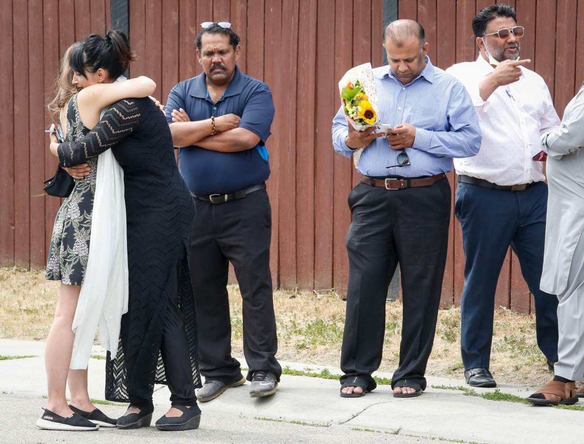 Mourners gather at the scene where seven people, including four children, died in a house fire in Chestermere, Alta., just east of Calgary, Friday, July 2, 2021.