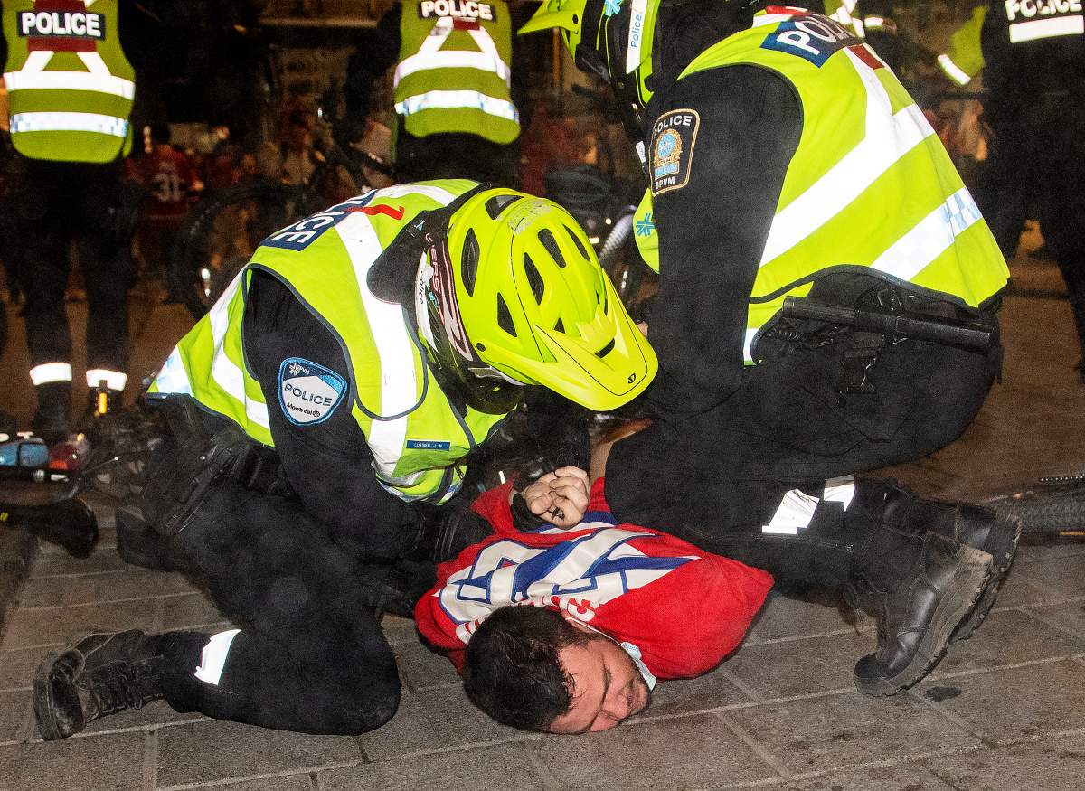 A Montreal Canadiens fan is taken down by police after the crowd was dispersed outside the Bell Centre in Montreal following the team’s overtime win in Game 4 of the NHL Stanley Cup final on Monday.