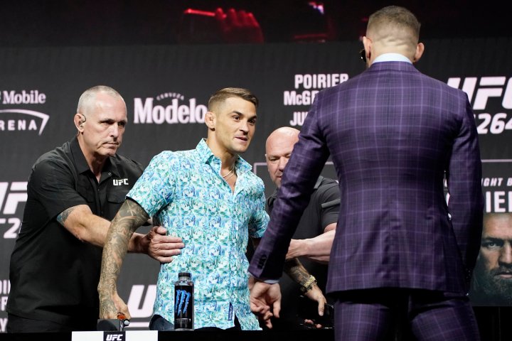 Security holds Dustin Poirier away from Conor McGregor, right, during a news conference for a UFC 264 mixed martial arts bout Thursday, July 8, 2021, in Las Vegas. The two are scheduled to fight in a lightweight bout Saturday in Las Vegas (AP Photo/John Locher)