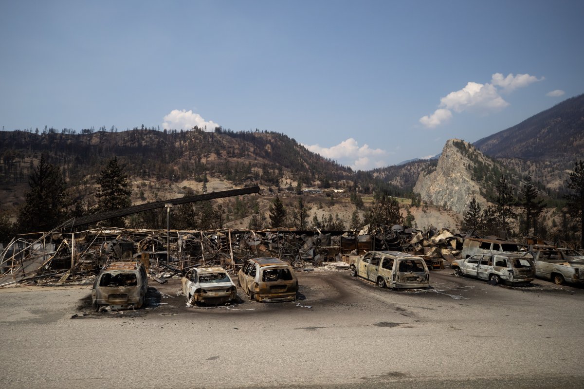 Cars destroyed by wildfire and a damaged structure are seen along the Trans-Canada Highway near Lytton, B.C., on Friday, July 9, 2021.