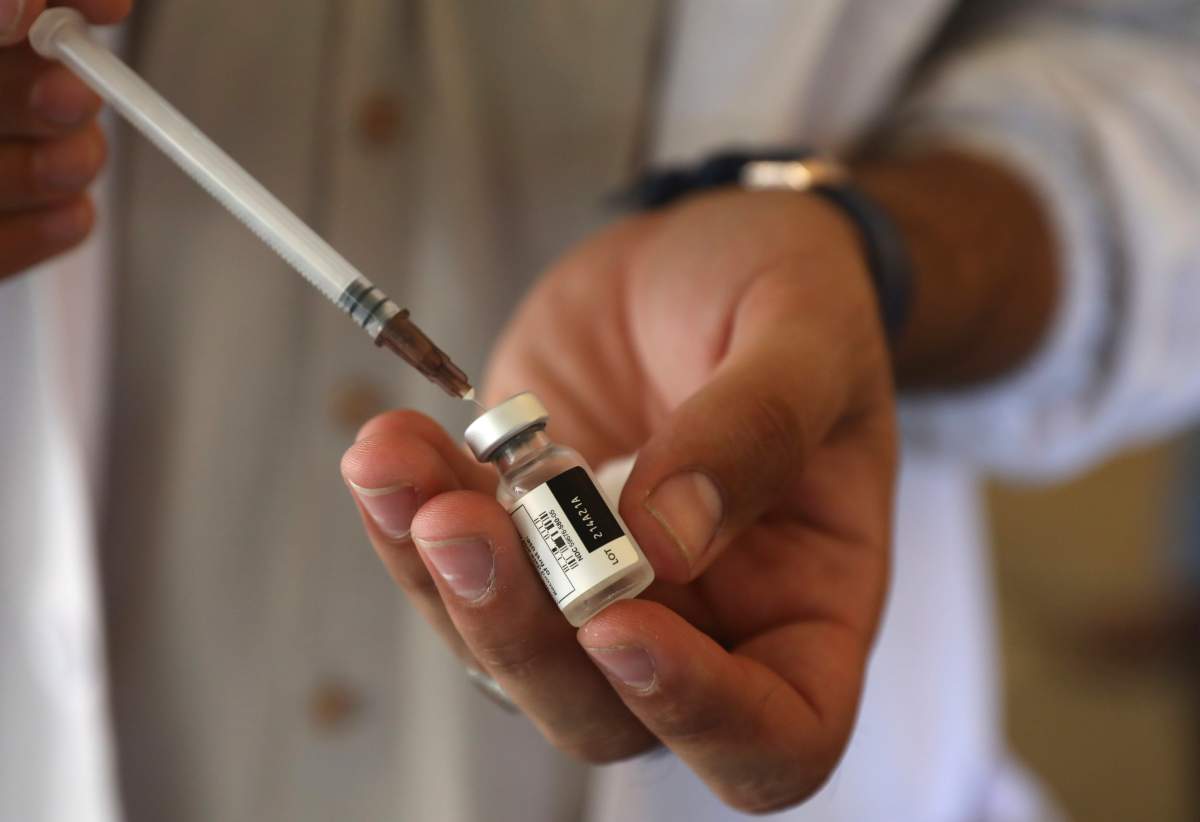 FILE - In this Sunday, July 11, 2021 file photo, a doctor fills a syringe with the Johnson & Johnson COVID-19 vaccine at a vaccination center in Kabul, Afghanistan.