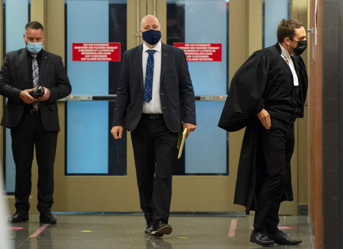 Montreal police officer Roger Frechette, centre, leaves the courtroom during a break in his sexual assault trial Tuesday, July 13, 2021 in Montreal. 