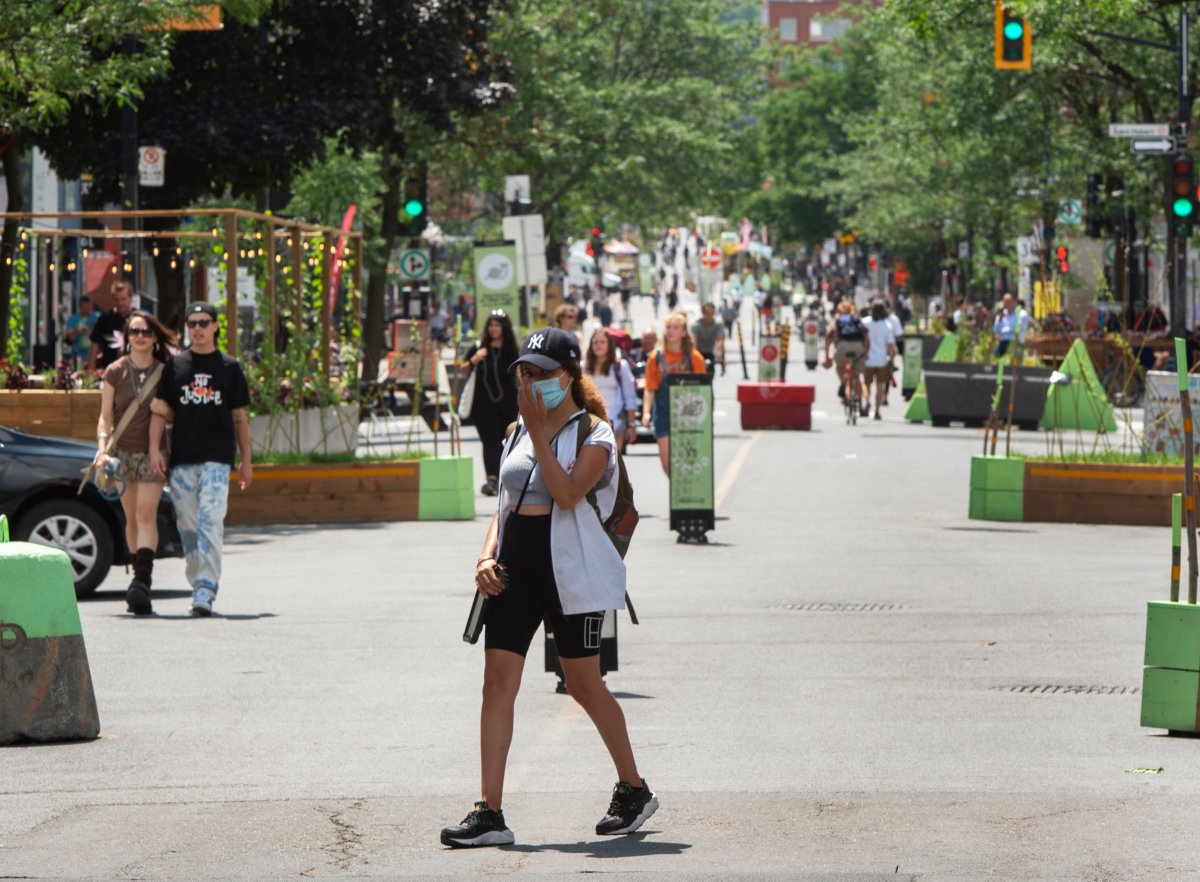 People take advantage of the warm weather as they walk down a pedestrian mall Wednesday, July 14, 2021  in Montreal.