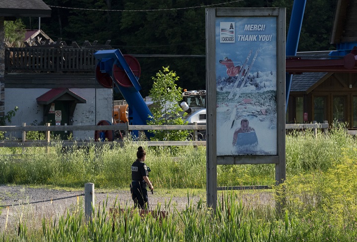 A police officer carries her gun as she examines an area at Mont Cascades water park in Cantley, Que. on Wednesday, July 14, 2021. 