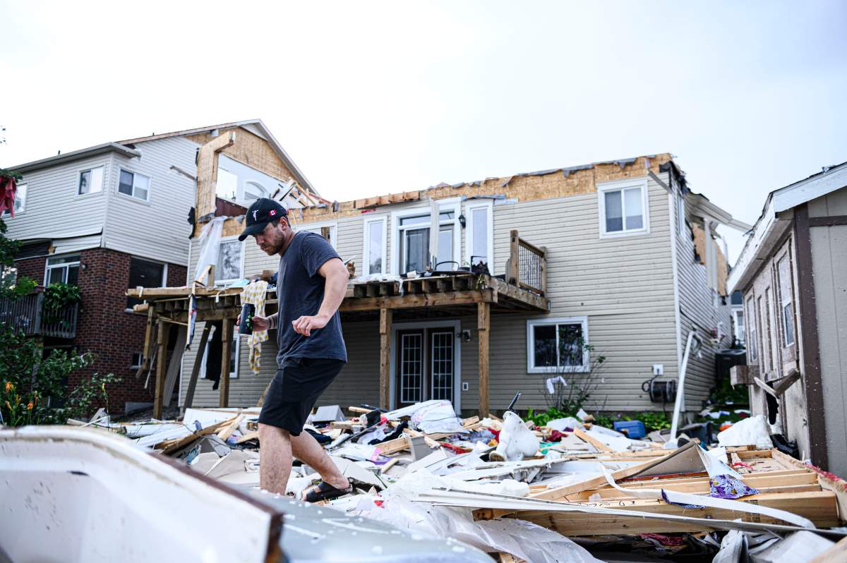 A resident surveys the damage left after a tornado touched down in his neighbourhood, in Barrie, Ont., on Thursday, July 15, 2021.