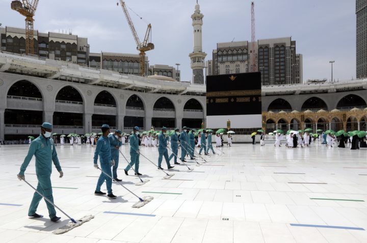 Arbeiter desinfizieren das Gelände, während muslimische Pilger einen Tag vor der jährlichen Hadsch-Pilgerfahrt, Samstag, 17. Juli 2021, die Kaaba, das kubische Gebäude der Großen Moschee, umrunden.