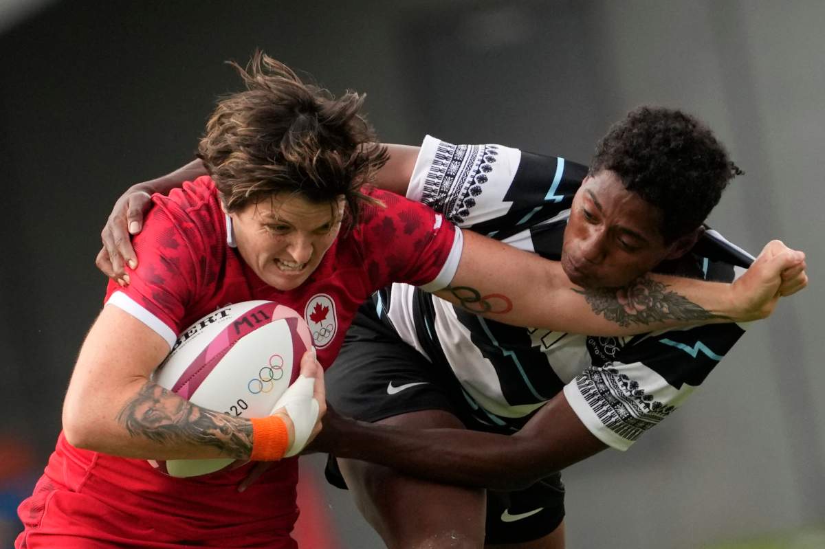 Canada's Britt Benn, left, is tackled by Fiji's Ana Maria Naimasi in their women's rugby sevens match at the 2020 Summer Olympics, Thursday, July 29, 2021 in Tokyo, Japan. (AP Photo/Shuji Kajiyama).