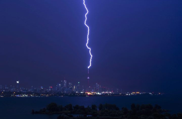 A lightning bolt strikes the CN Tower during an electrical storm in Toronto, early Thursday July 14, 2016.