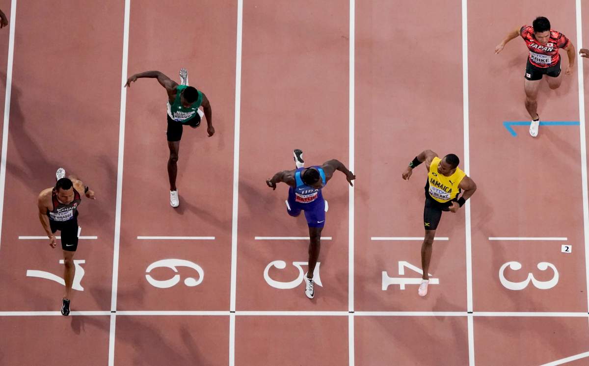 Andre De Grasse, of Canada, crosses the finish line ahead of Yohan Blake, of Jamaica, and Justin Gatlin, of the United States, in a men's 100 meter semifinal at the World Athletics Championships in Doha, Qatar, Saturday, Sept. 28, 2019. (AP Photo/Morry Gash).