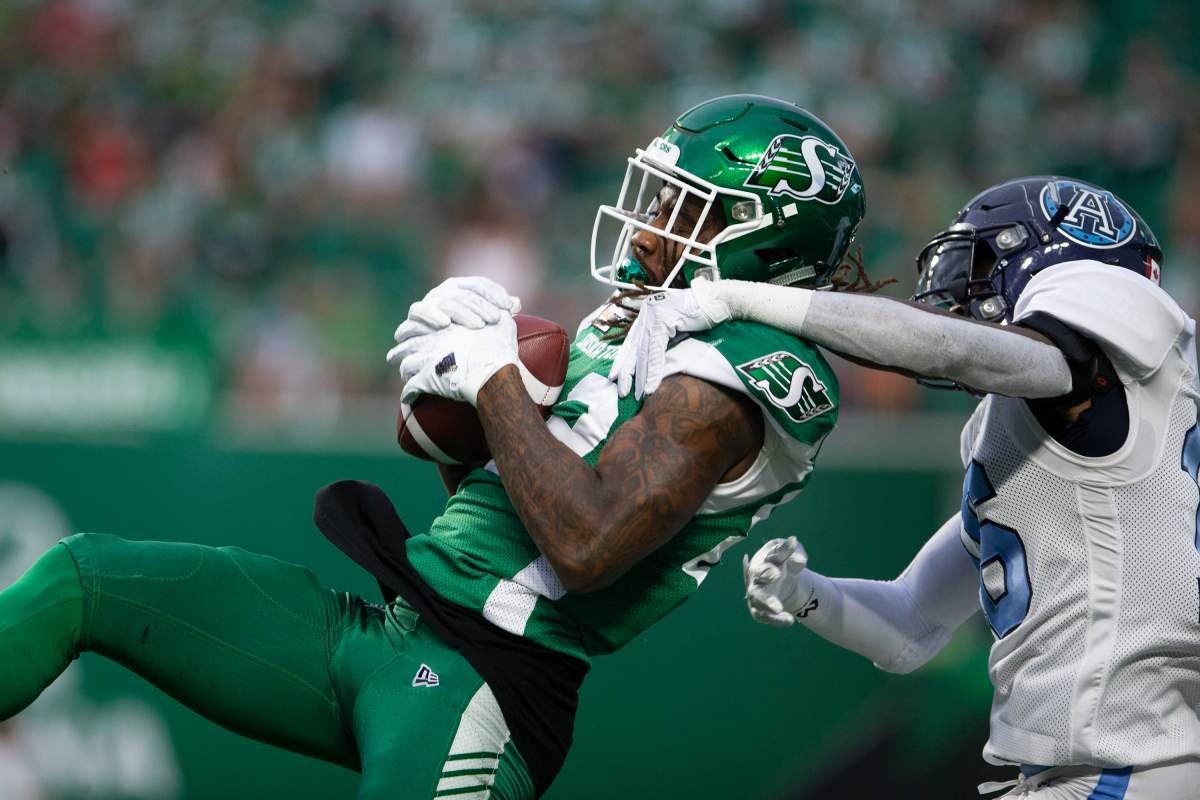 Saskatchewan Roughriders' Naaman Roosevelt (82) makes a catch as Toronto Argonauts' Caleb Ham (16) goes to block during first half CFL football action in Regina on Monday, July 1, 2019. 