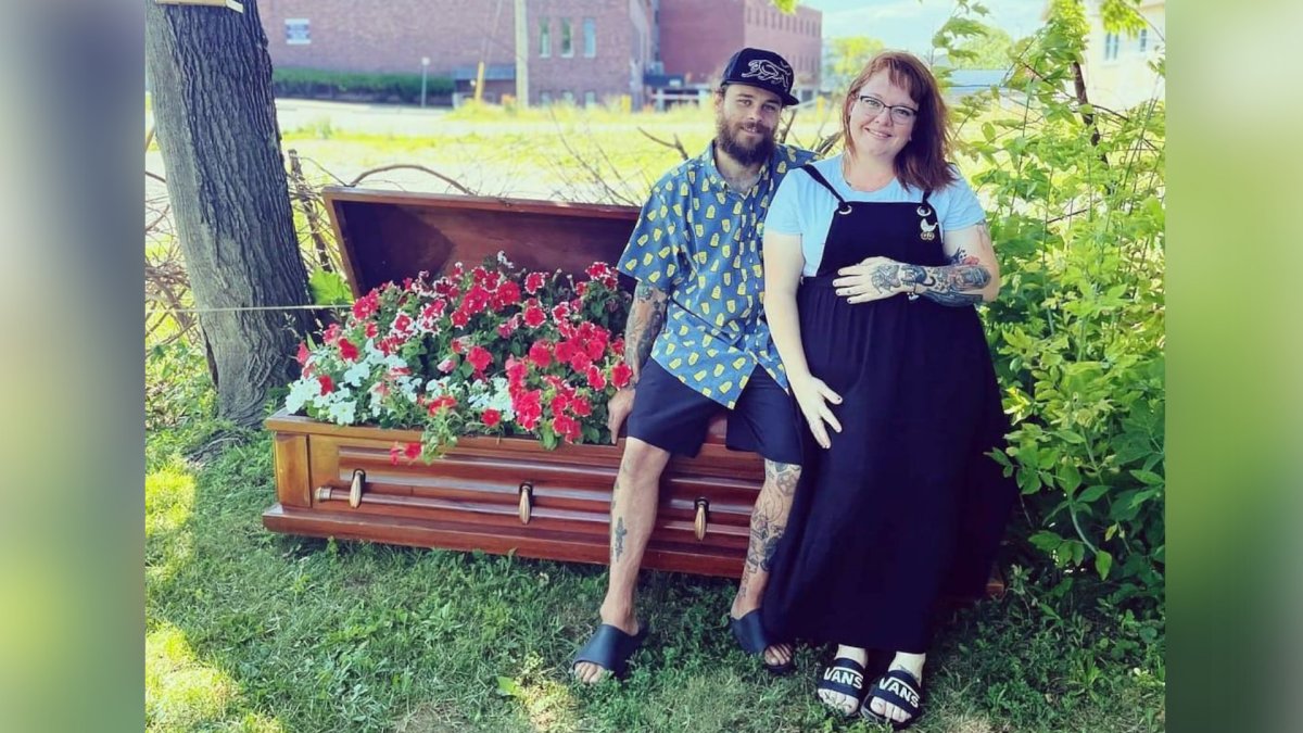 St. Catharines resident Christina Calbury and boyfriend sitting with a coffin flowerbed she will now be allowed to keep in her front yard.