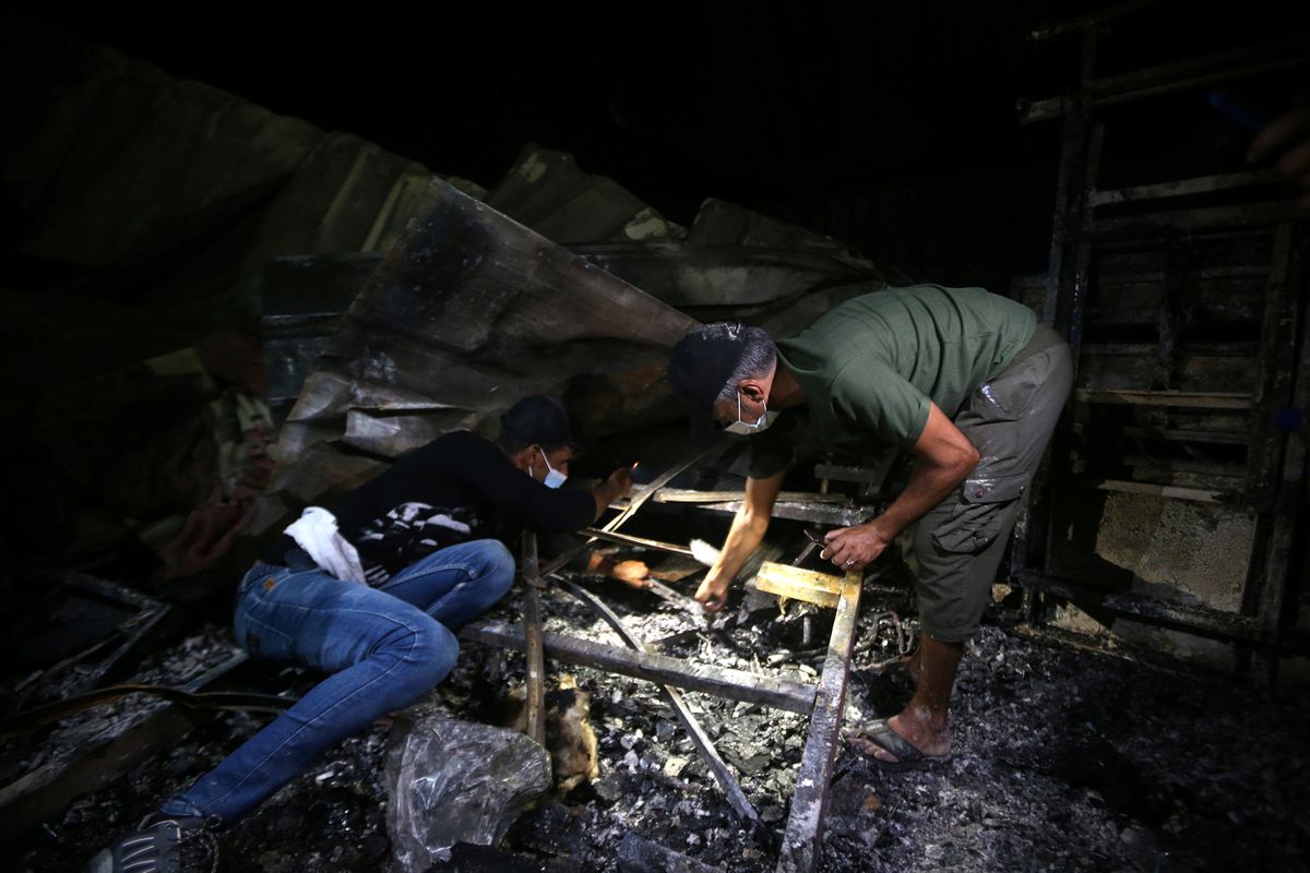 People inspect the damage at the site where a fire broke out at al-Hussain coronavirus hospital, in Nassiriya, Iraq, July 13, 2021. 