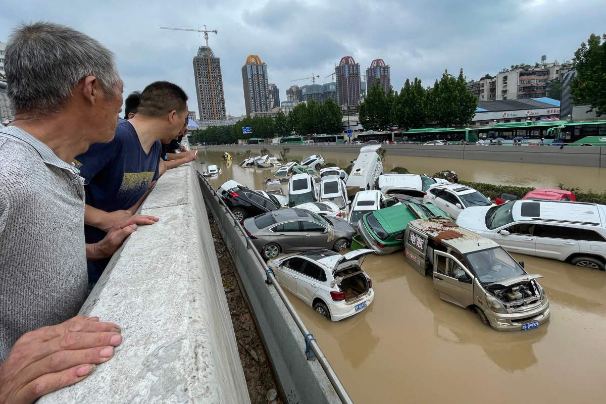 People look out at cars sitting in floodwaters after heavy rains hit the city of Zhengzhou in China’s central Henan province on July 21, 2021.