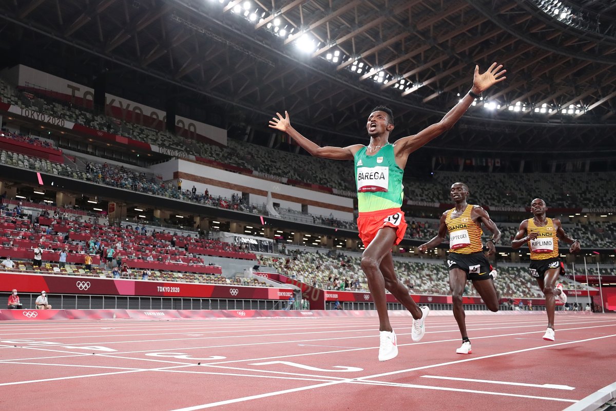 Gold medalist Selemon Barega of Team Ethiopia celebrates as he crosses the finish line ahead of silver medalist Joshua Cheptegei of Team Uganda and bronze medalist Jacob Kiplimo of Team Uganda in the Men's 10,000 metres Final on day seven of the Tokyo 2020 Olympic Games at Olympic Stadium on July 30, 2021 in Tokyo, Japan. 