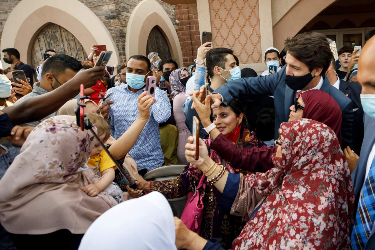 Canada's Prime Minister Justin Trudeau takes selfies with community members at the Hamilton Mountain Mosque after speaking to the congregation to recognize Eid al-Adha in Hamilton, Ont., Tuesday, July 20, 2021.THE CANADIAN PRESS/Cole Burston.