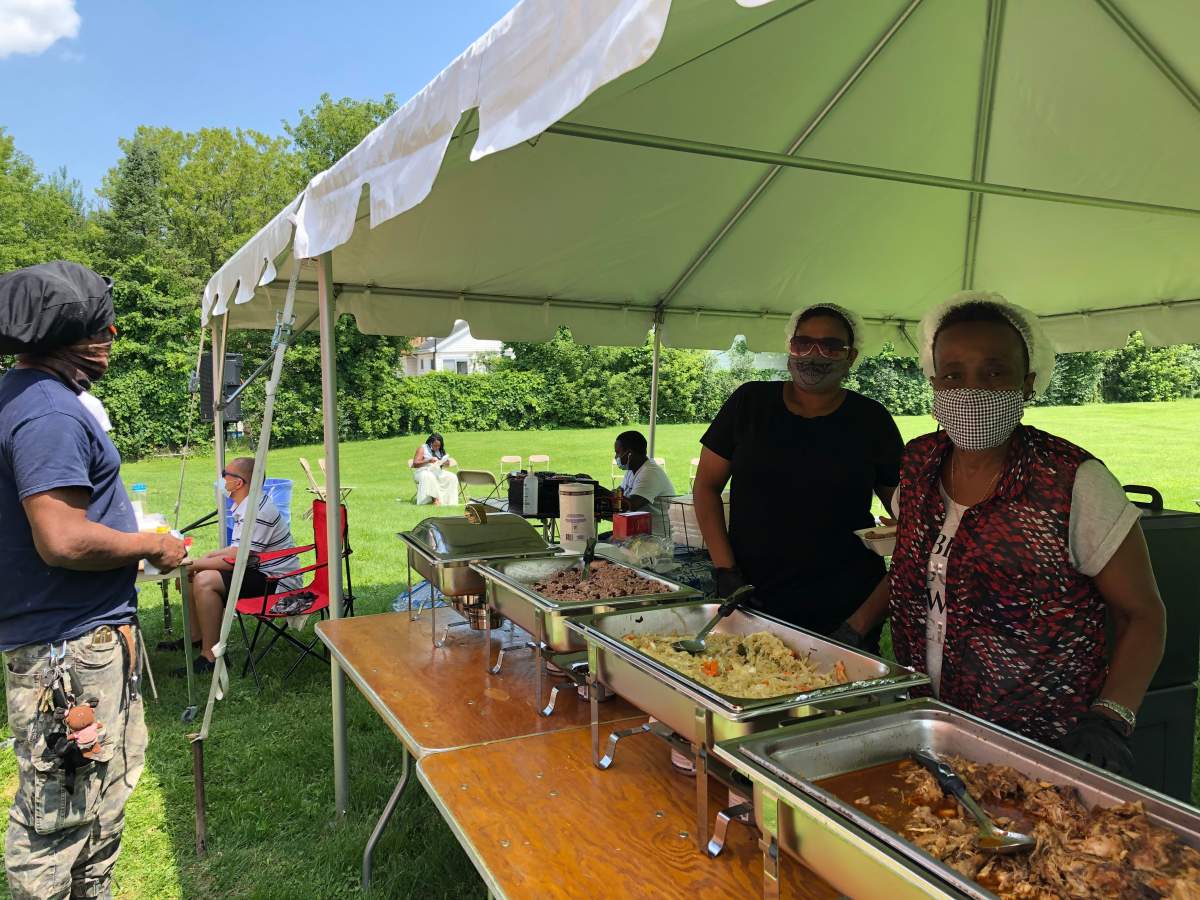 Volunteers with Black London Network serve up free food from Richie's Caribbean Restaurant for visitors to Friday's pop-up clinic.
