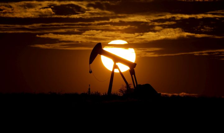 In this Wednesday, April 8, 2020, file photo, the sun sets behind an idle pump jack near Karnes City, USA.  