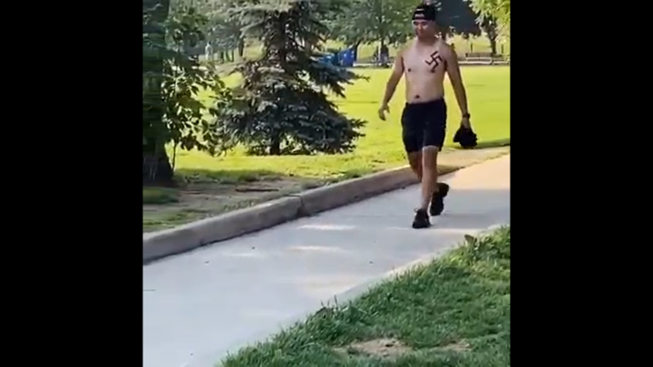 A video appears to show a man with a swastika on his chest.