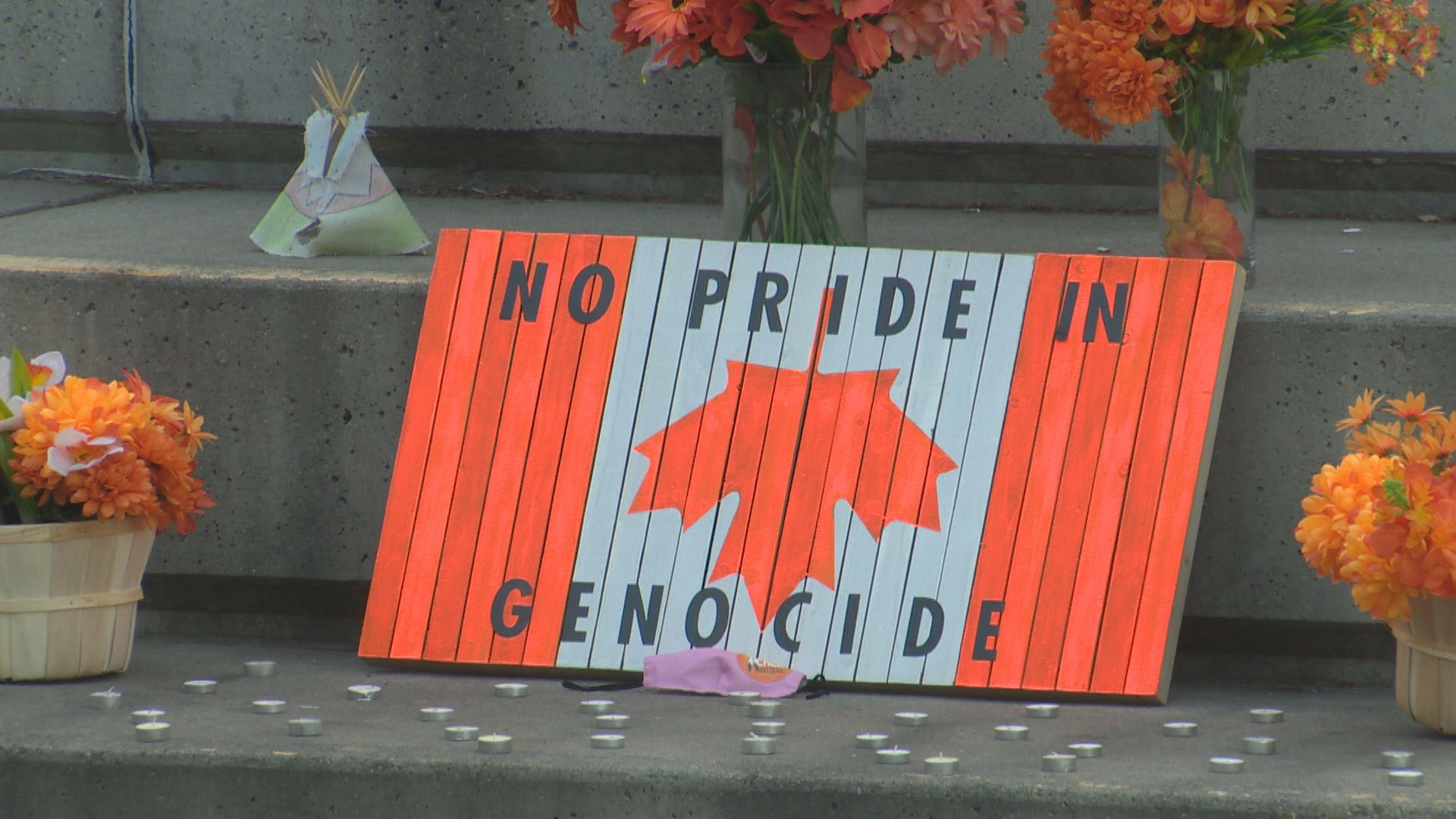 A sign stands before a candlelight vigil in Galt Gardens, honouring children sent to residential schools on July 1, 2021.
