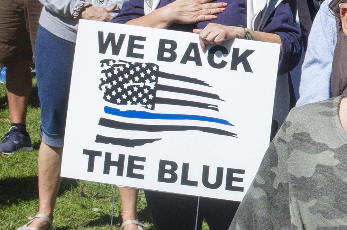 In this file photo, a protester holds a ‘Back the Blue’ sign at a demonstration in Malverne, N.Y., on Sept. 19, 2020.