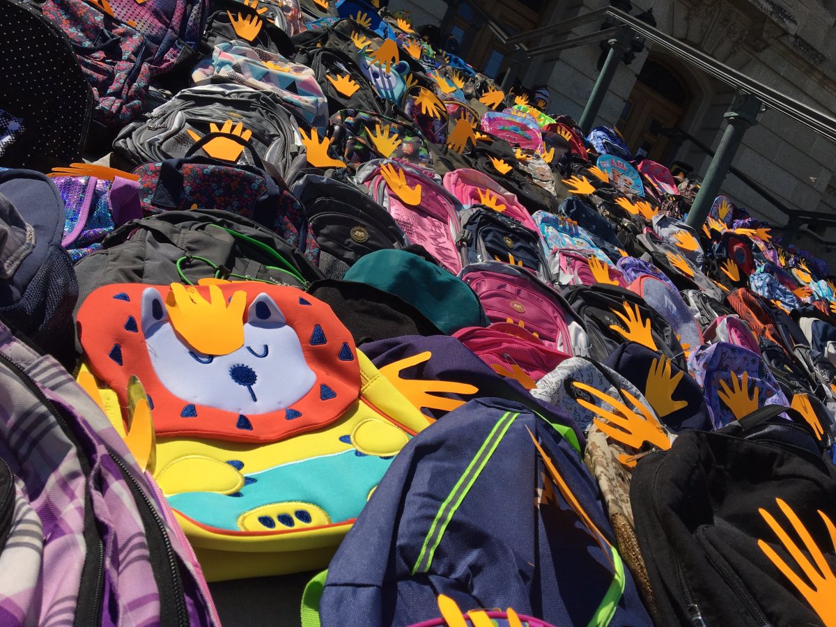 Hundreds of backpacks line the steps of the provincial legislative building to represent unmarked graves found at residential schools.