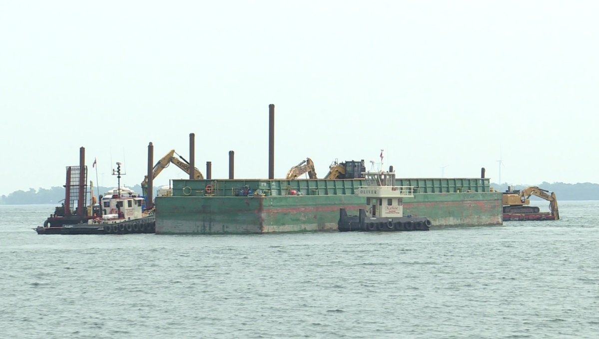 A barge was out along downtown Kingston's waterfront Monday to start dredging a path for a large ferry, expected to arrive next year. 