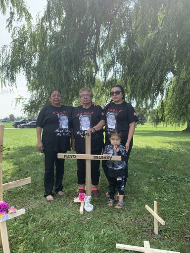 A family places a cross outside EMDC in honour of their family member, Floyd Deleary, who died inside the facility. (July 17, 2021)
