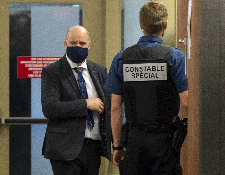 Montreal police officer Roger Fréchette, left, enters the courtroom after a break in his sexual assault trial Tuesday, July 13, 2021 in Montreal. 