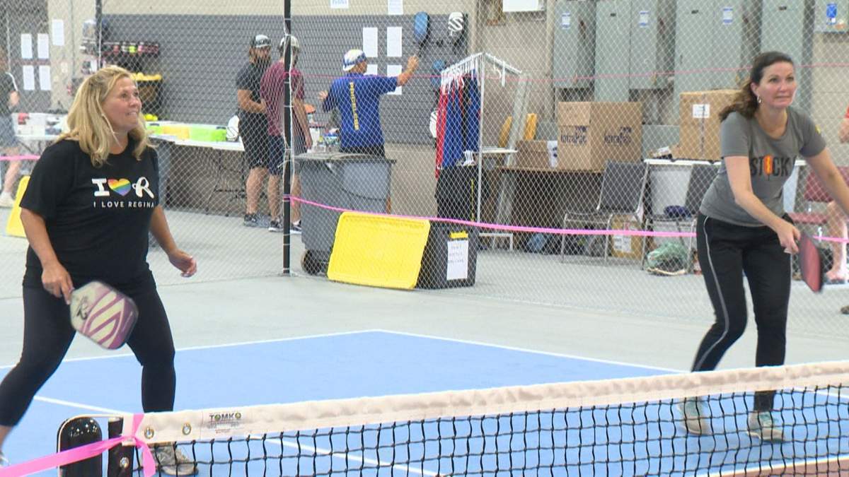 Regina city councillor Lori Bresciani and Regina mayor Sandra Masters await the return ball at the Regina Pickleball Hub.