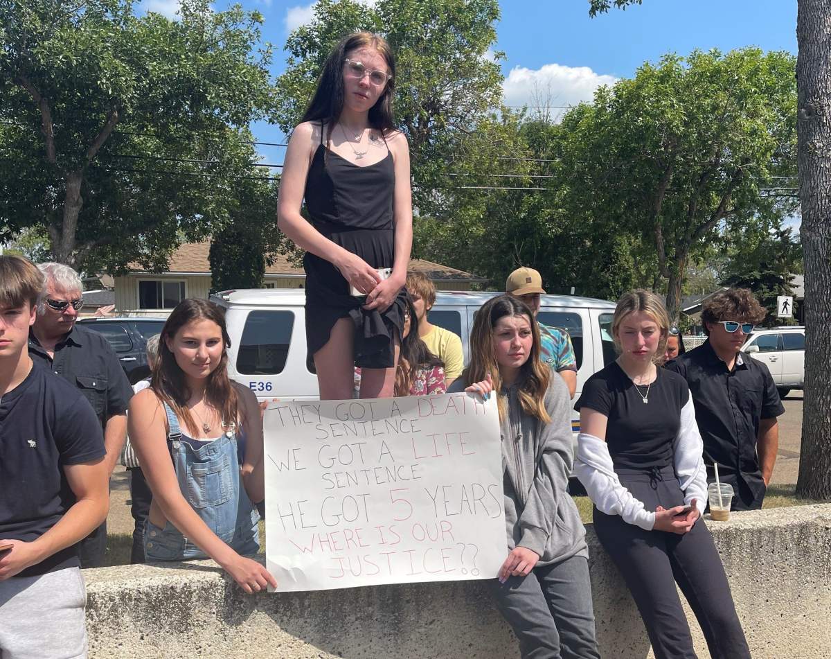 Morgan Maltby (centre standing) stands outside the courthouse in Edmonton Monday, July 12, 2021 following the sentencing of Christopher D. Rempel.