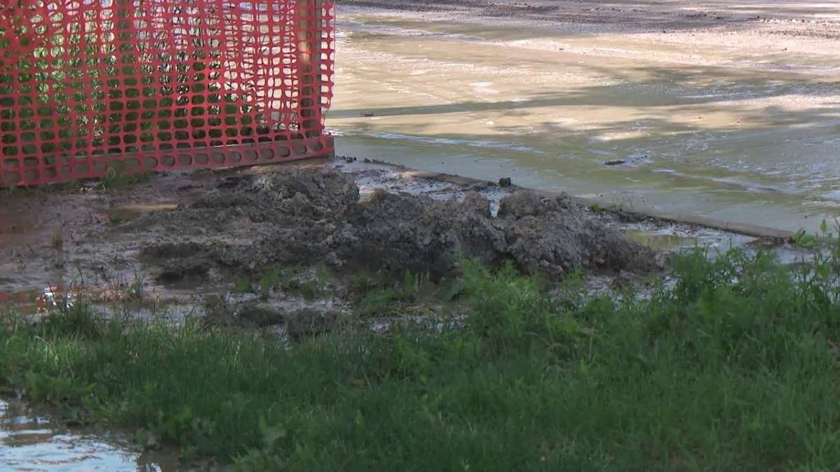 Thick mud covers properties in the area of 101 Street and 116 Avenue in Edmonton Monday, July 5, 2021, one day after a water main break in the area.
