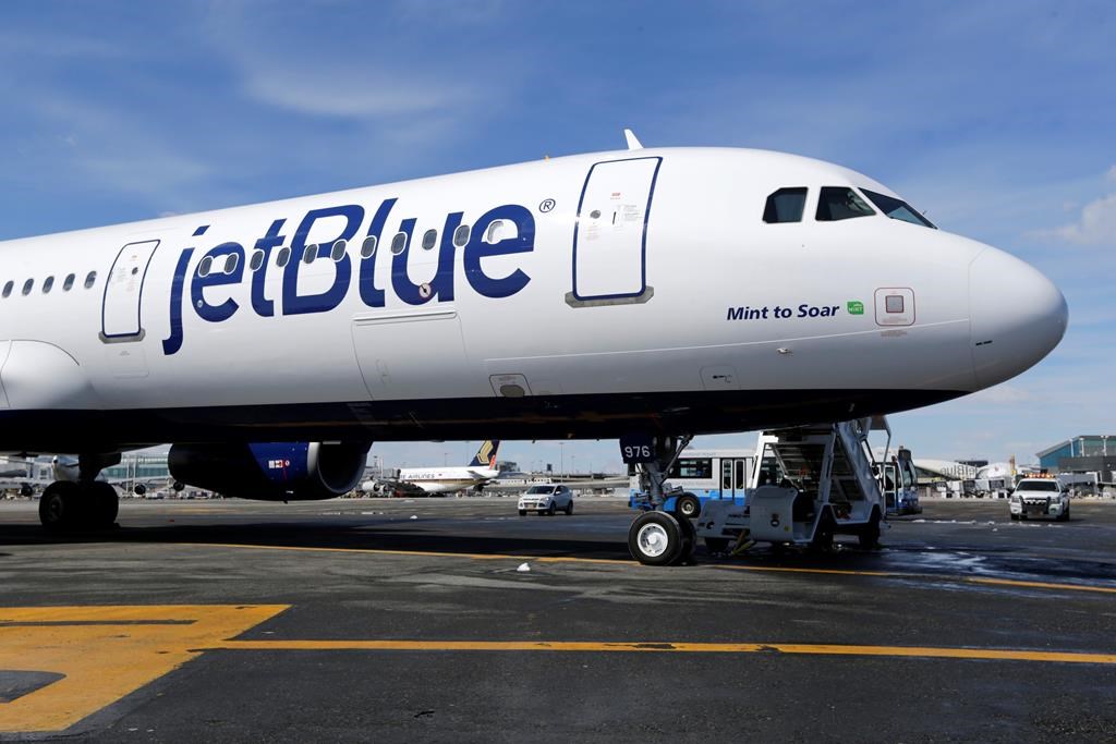 a jetblue airplane sits on a runway